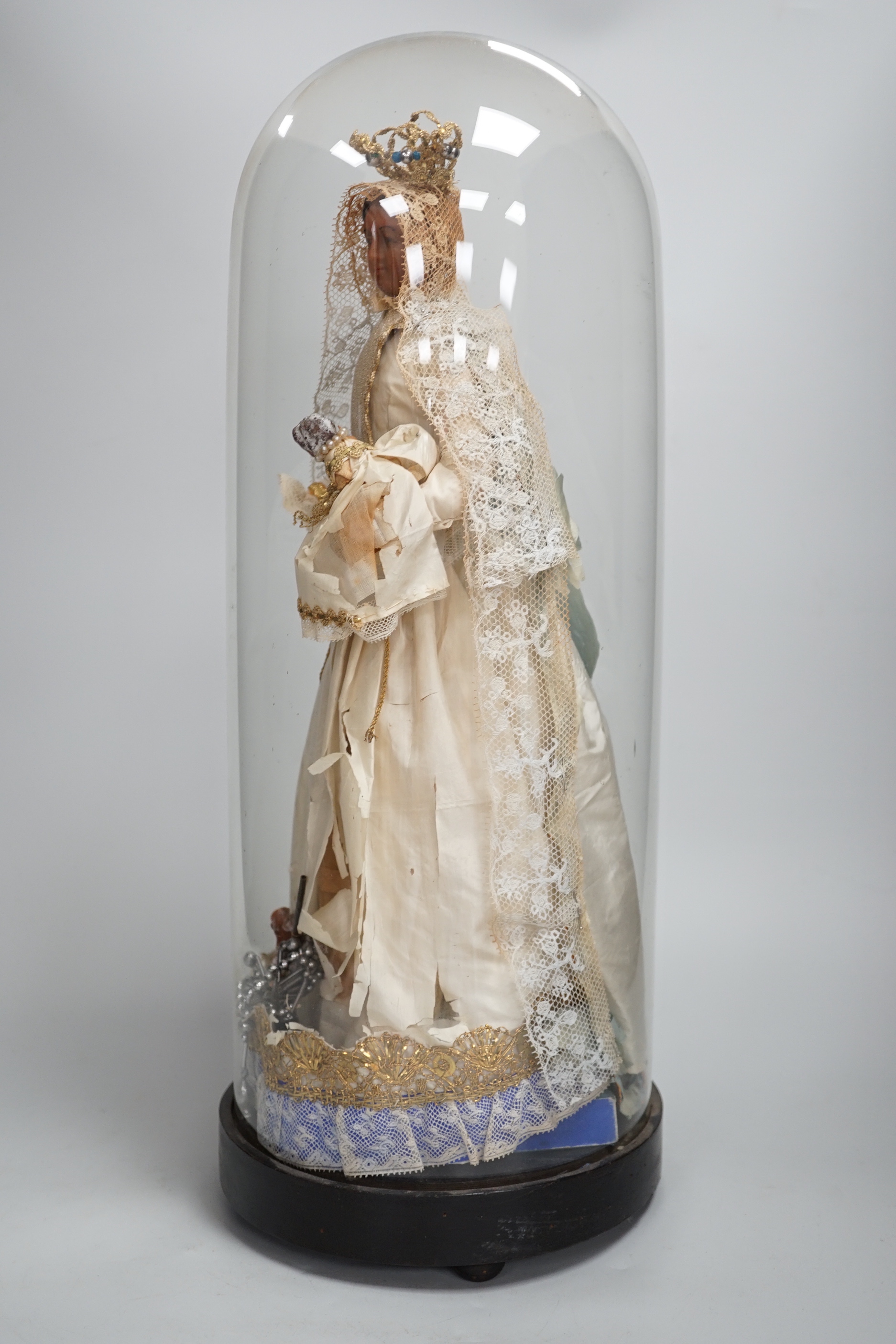 A waxed dressed figure with crown holding a baby under a glass dome 49.5cm high